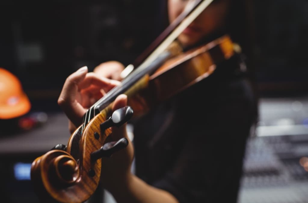 violinist's fingers pressing the strings, with a blurred background emphasizing motion and sound