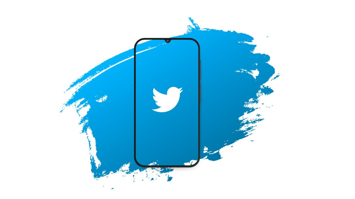 A smartphone with the Twitter logo on-screen, set against a blue background